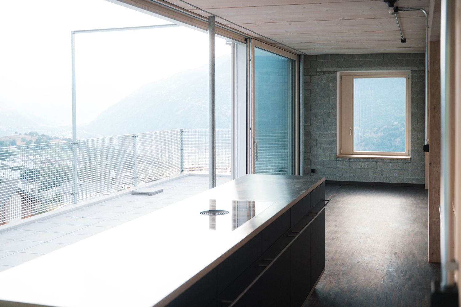 Küche mit Kochinsel und Panoramafenster zur Dachterrasse